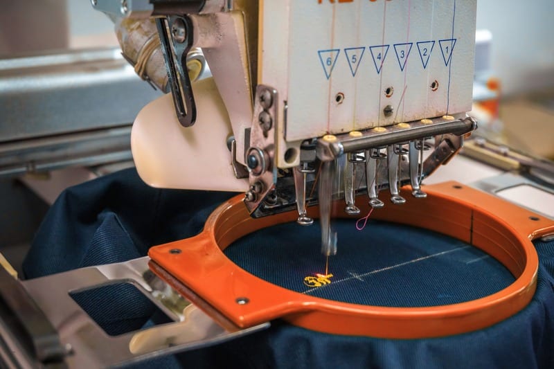Stickmaschine mit orangem Stickrahmen